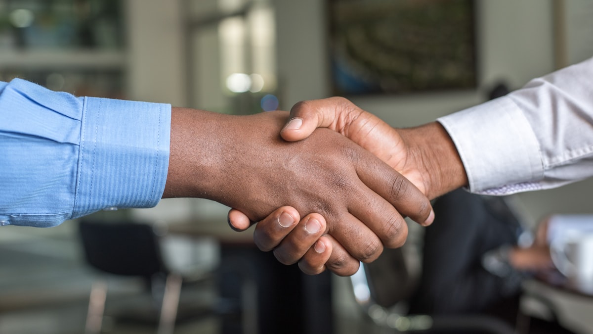 Venture capital investor and startup founder shaking hands on term sheet