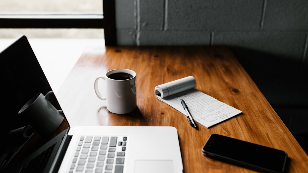 Self-employed freelance consultant working on laptop with invoices