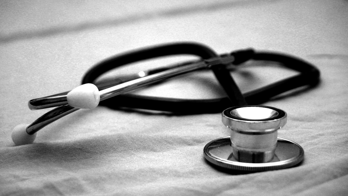 Doctor with stethoscope holding medical clipboard in consultation